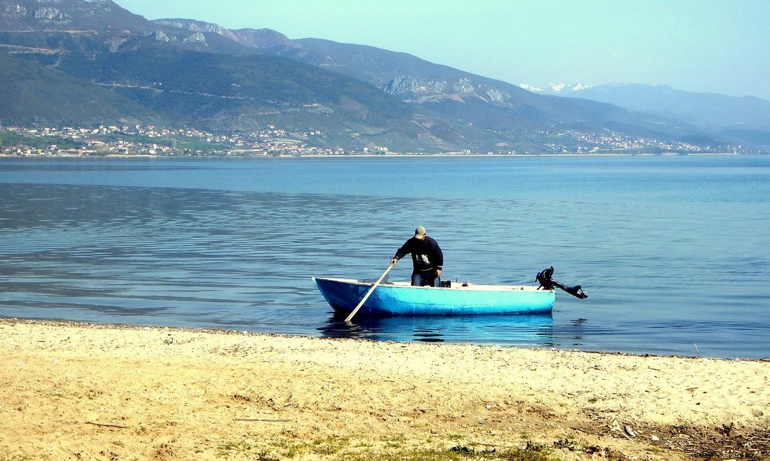 A man on a motorboat on the shores of Lake Ohrid in Albania